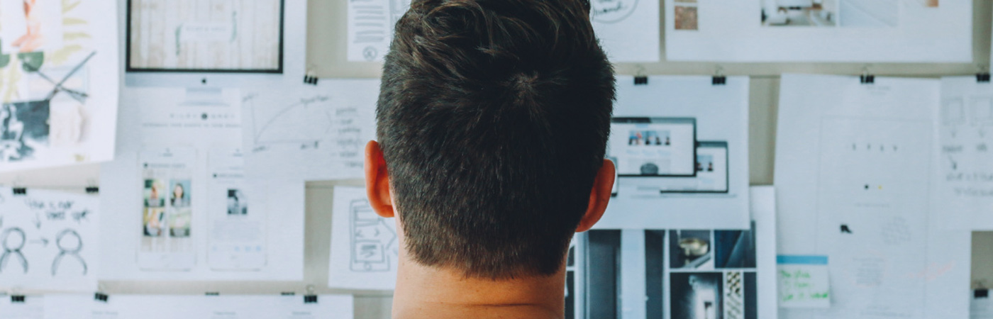 man looking at notes on wall